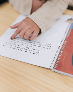 Kinderhand folgt einer Zeile in einem Übungsheft